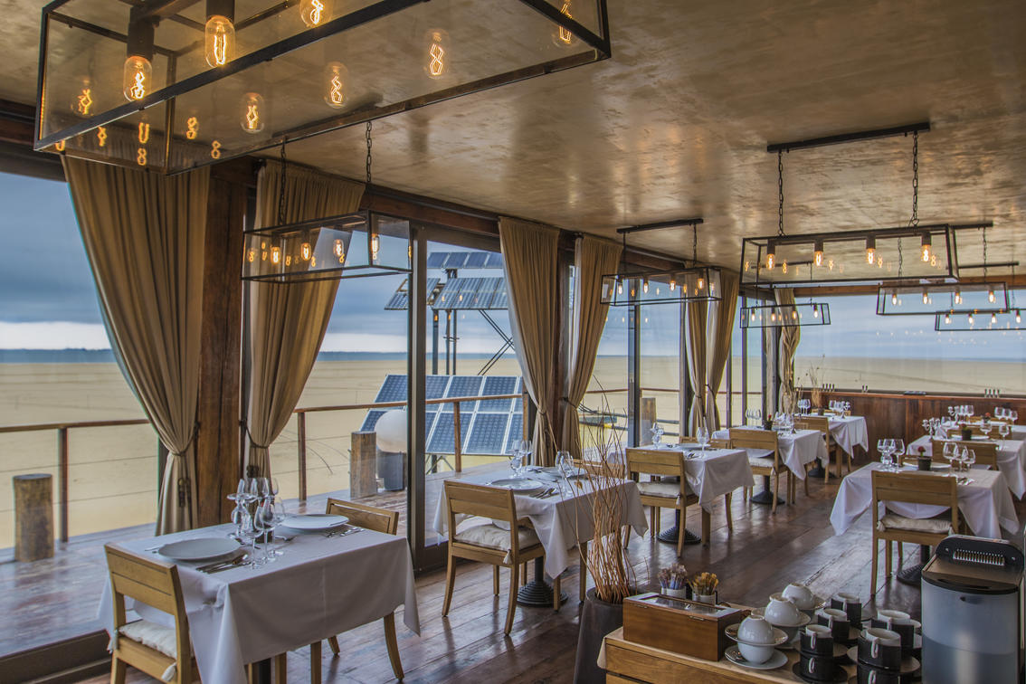<p>Dining room looking out over the sandy beach</p>